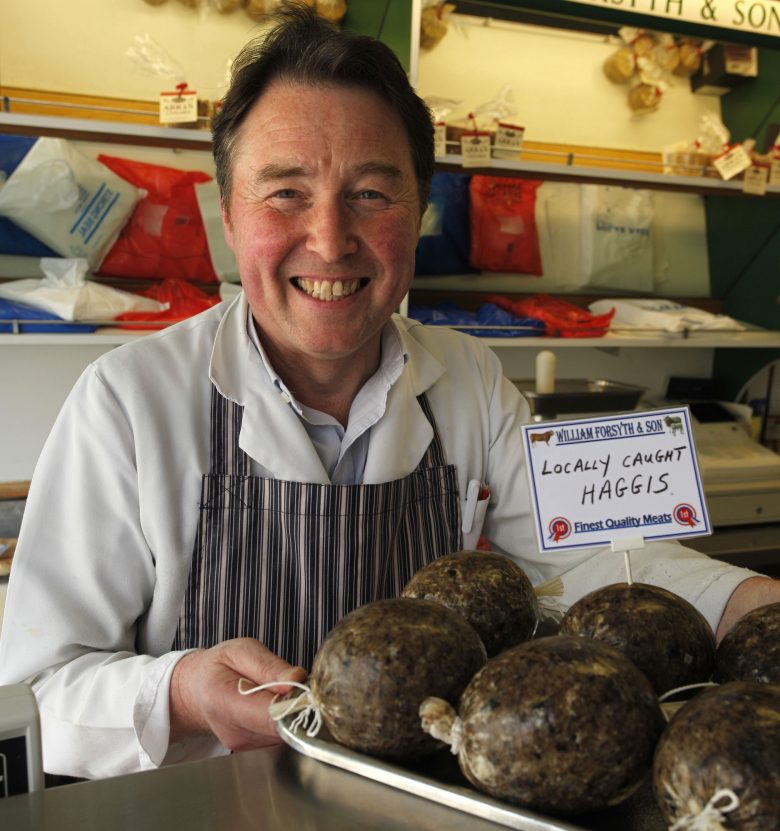 Butcher with haggis at William Forsyth & Son, a traditional family butchers in Sanquhar, Upper Nithsdale, Dumfries & Galloway